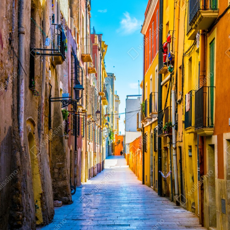 Repositionierbarer Aufkleber sonnenbeschienene mediterrane gasse mit bunten fassaden – Wallnifity® Repositionierbarer Aufkleber sonnenbeschienene mediterrane gasse mit bunten fassaden – Wallnifity®