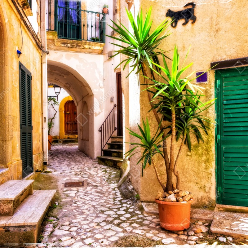 Repositionierbarer Aufkleber sonnige mediterrane gasse mit grünen jalousien – Wallnifity® Repositionierbarer Aufkleber sonnige mediterrane gasse mit grünen jalousien – Wallnifity®