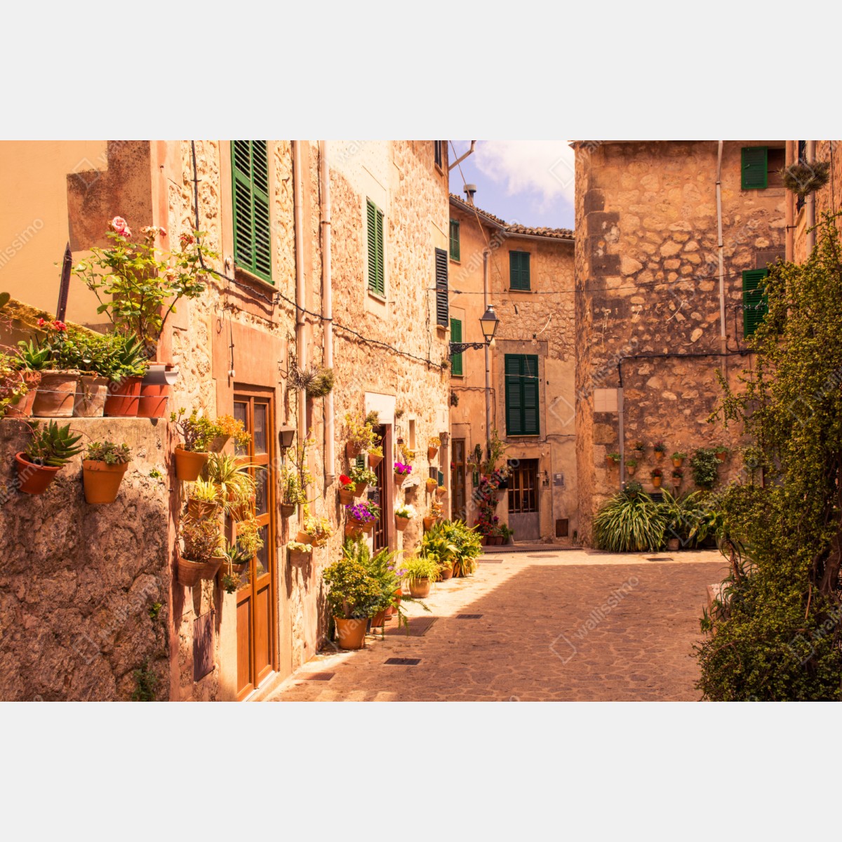 Repositionierbarer Aufkleber sonnige mediterrane gasse mit blumentöpfen – Wallnifity® Repositionierbarer Aufkleber sonnige mediterrane gasse mit blumentöpfen – Wallnifity®