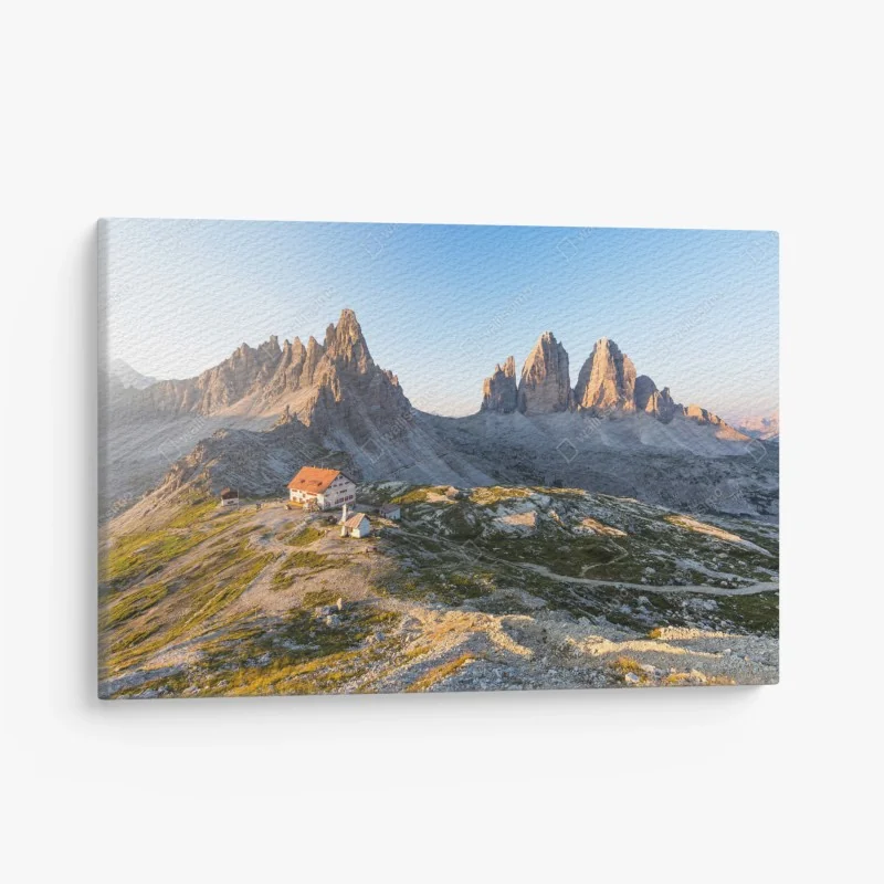 Leinwandbild sonnenbeschienene berghütte und alpine gipfel