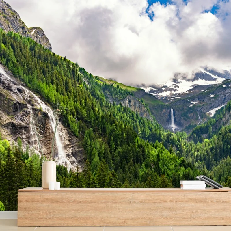 Fototapete nebelverhangener alpenwasserfall über grüner waldschlucht