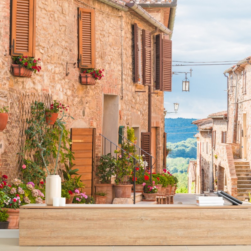 Fototapete mittelalterliche straße in der Toskana mit blumentöpfen