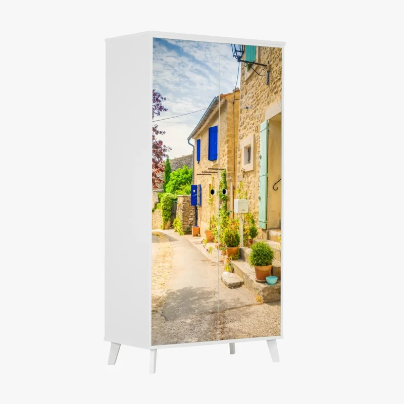 Schrankaufkleber sonnenbeschienene dorfstraße mit steinhäusern und bunten fensterläden