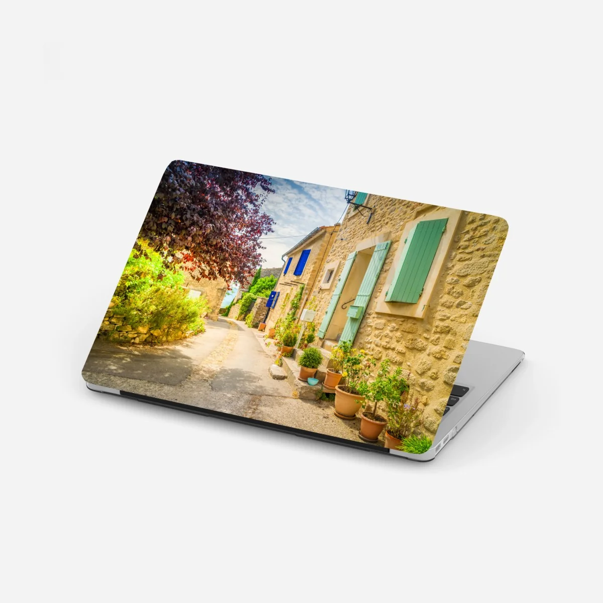 Laptop-Aufkleber sonnenbeschienene dorfstraße mit steinhäusern und bunten fensterläden – Wallnifity®