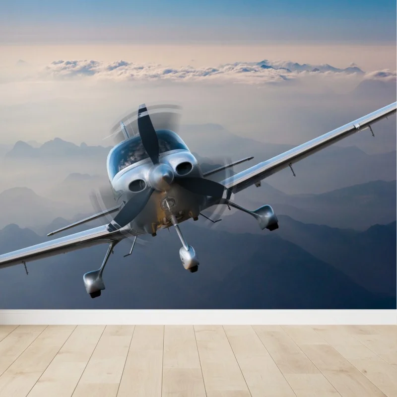 Fototapete silbernes propellerflugzeug über nebeligen bergen